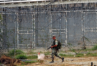 A soldier escorts Wattle through the prison yard.